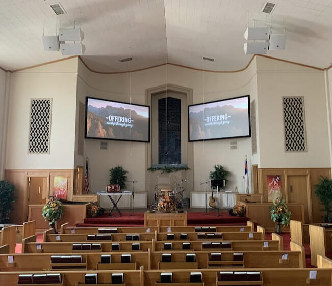 Church sanctuary with projectors, speakers, and screens